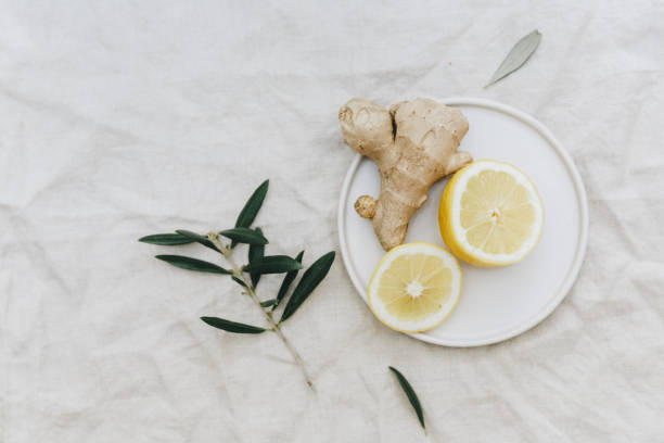 Flat lay lemon with ginger over linen tablecloth. Top view stock photo