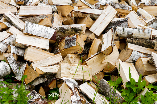 Chopped logs for winter fire. Pile of chopped fire wood prepared for winter. Chopped firewood texture background