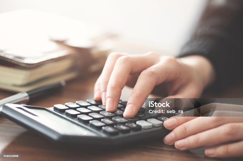 Hand using calculator on the table Calculator Stock Photo