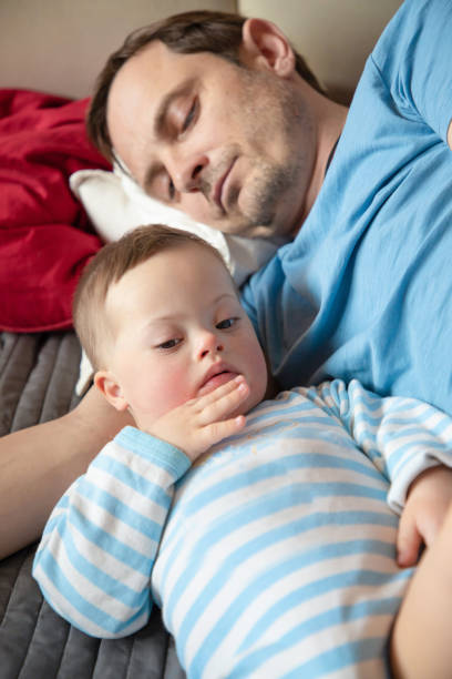 istock Cute baby boy with Down syndrome playing with dad 948024196