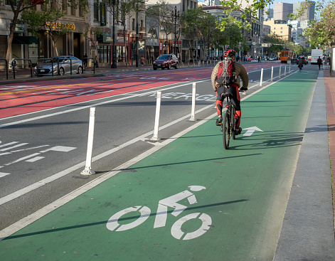 SAN FRANCISCO, CA - APRIL 12, 2018: A cyclist uses a designated bike lane on Market Street on their commute in San Francisco.