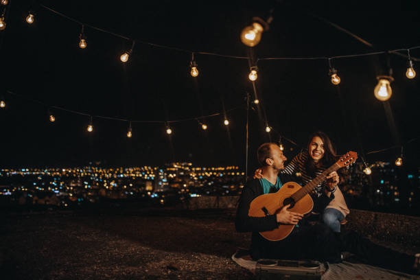 istock Cheerful young couple on a rooftop party 948036004