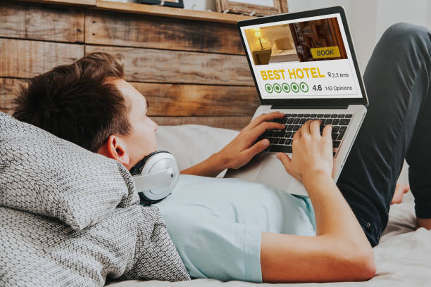 istock White man booking the best hotel by internet with a laptop computer at home. 948042626