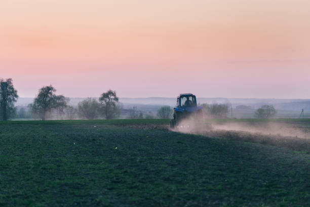 istock Agricultural machinery in field on the Sunset 948044264