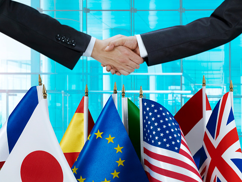 Handshake in front of National Flags