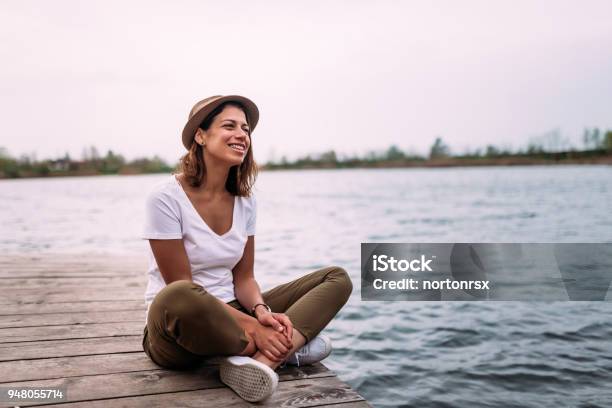 Young Woman Relaxes On The Edge Of A Wooden Jetty Stock Photo - Download Image Now - Women, One Woman Only, Close To