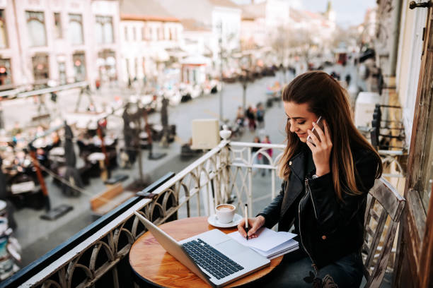 istock Young female entrepreneur working while sitting on the balcony at the city. 948055764