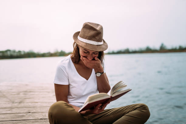 istock Girl reading funny book and laughing. 948055818