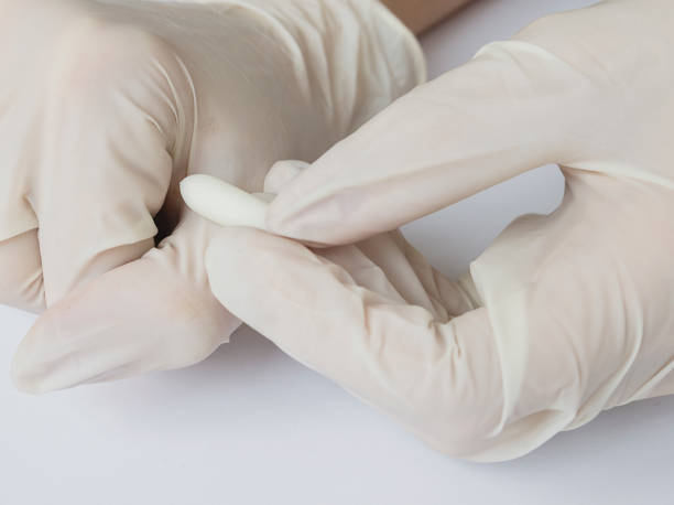 istock Doctor's hands with rectal or vaginal suppository, explains how to apply, concept, close-up 948060112