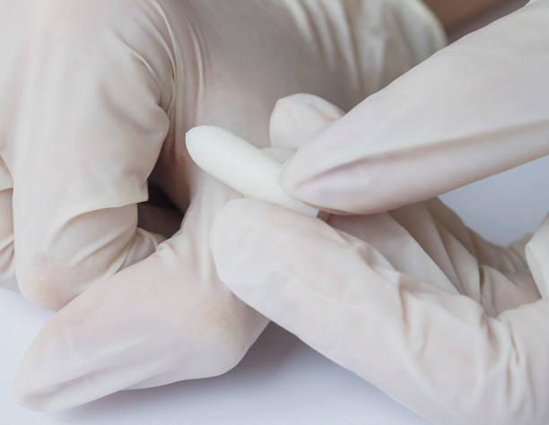 istock Doctor's hands with rectal or vaginal suppository, explains how to apply, concept, close-up 948060118