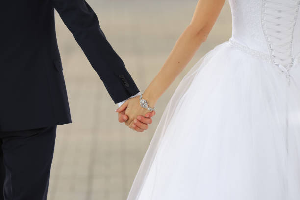 istock Wedding couple holding hands close up 948081558