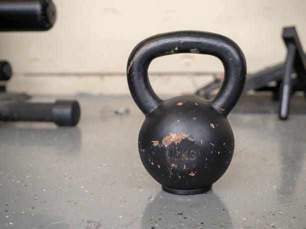 istock Black, 10 kg kettlebell sitting on hard gym floor with space to left 948089666