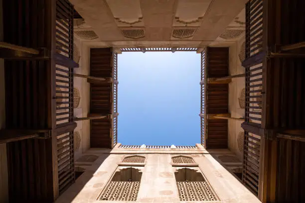 View of a blue sky through a traditional Omani fort courtyard. Nizwa, Oman.