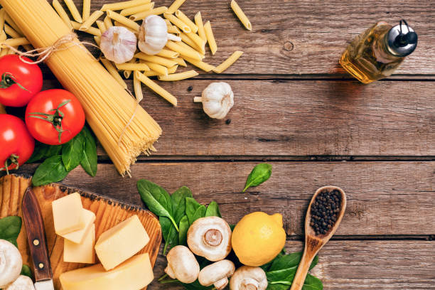 istock Ingredients for spaghetti with basil, tomatoes, cheese on wooden background, top view, place for text 948113598