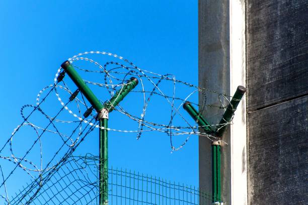 istock Fence with razor barbed wire. Guarded area. Military base. Razor wire. 948117198