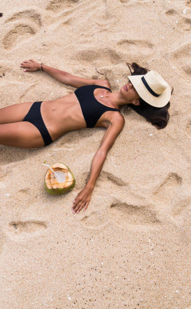 istock Young woman sunbathing on the Beach 948122456