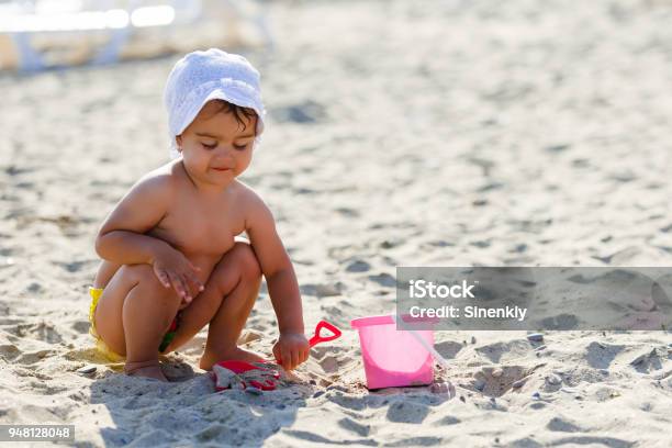 Premium Photo  Baby girl on a sandy beach near the river holds a