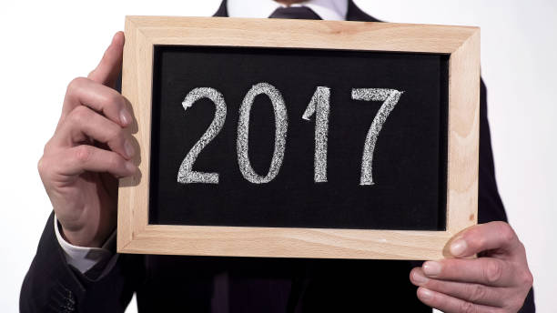 istock 2017 written on blackboard in businessman hands, annual report, motivation 948128370