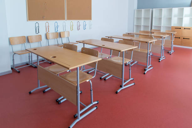 istock Empty classroom with wooden desks and chairs 948129072