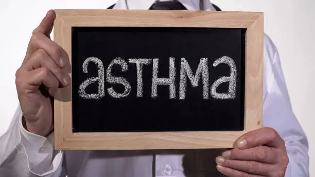 Photo of Asthma written on blackboard in doctor hands, genetic lung disease, bad ecology