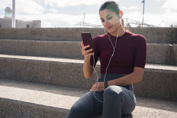 istock Pretty sporty brunette looking at phone 948136164