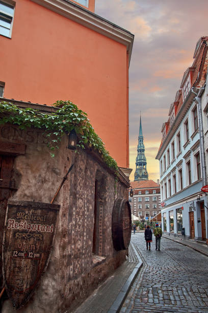 Old medieval street at night with Saint Peters Lutheran church in Riga, Latvia in the background