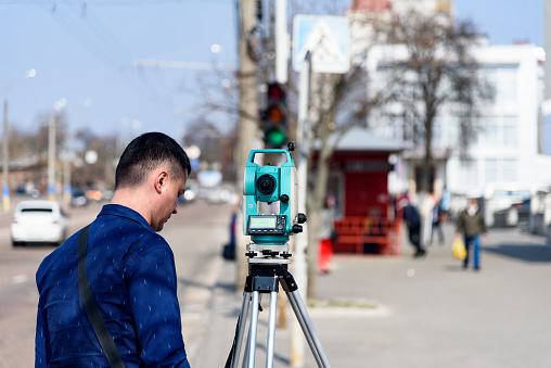 engineer land surveyor makes measurements on the street of the city of Chernigov, Ukraine, April 2018, editorial
