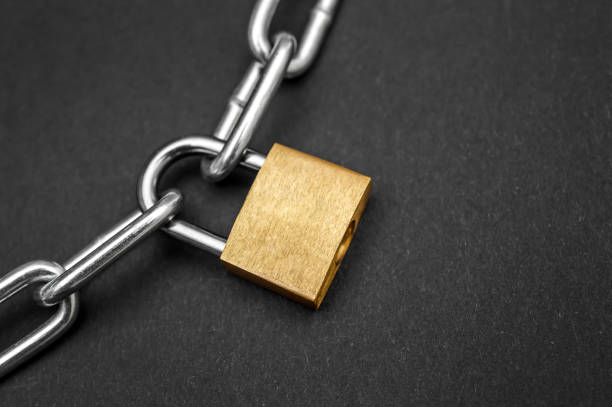 istock Golden padlock with chain on black background. 948157132