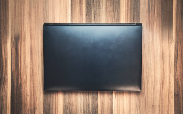 istock Closed laptop on the wooden table. 948157908