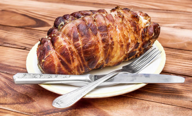 istock Plate with smoked meat, fork and knife on the table. 948158374
