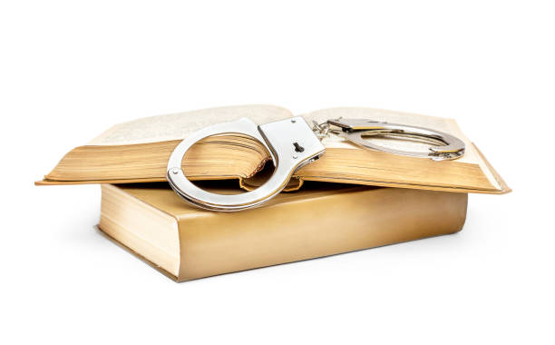 istock Handcuffs with books on white background. 948163852