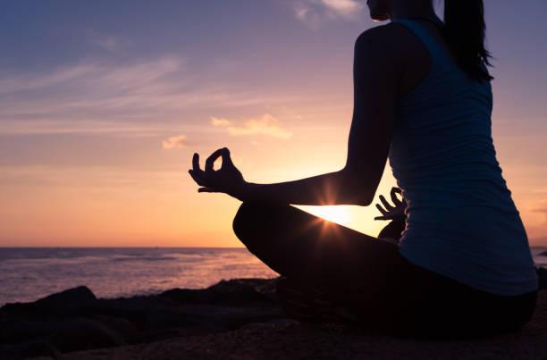 istock Woman meditating on the beach 948164652