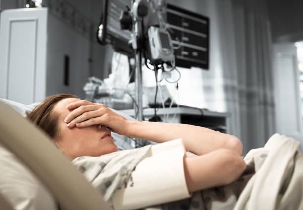 Young woman patient lying at hospital bed feeling sad and depressed worried. Disease feeling sick in health care and clinical attention concept sick woman hospital bed stock pictures, royalty-free photos & images
