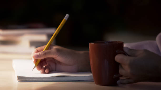istock Lady journalist making notes in her notebook drinking coffee in cozy atmosphere 948171658