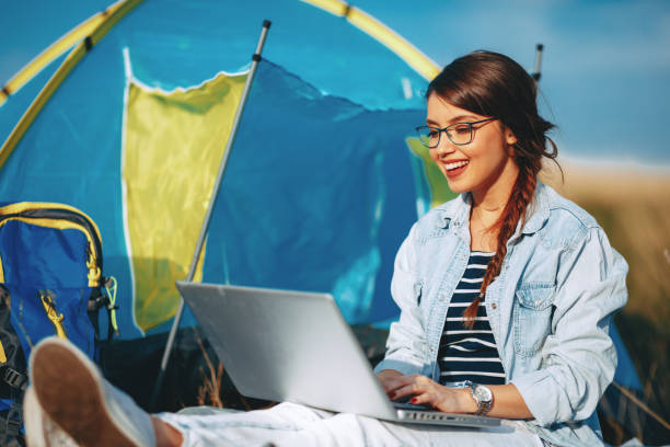 istock Young woman using laptop in the camp 948172698