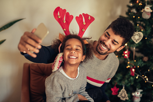 Cute african american girl making a selfie with dad.