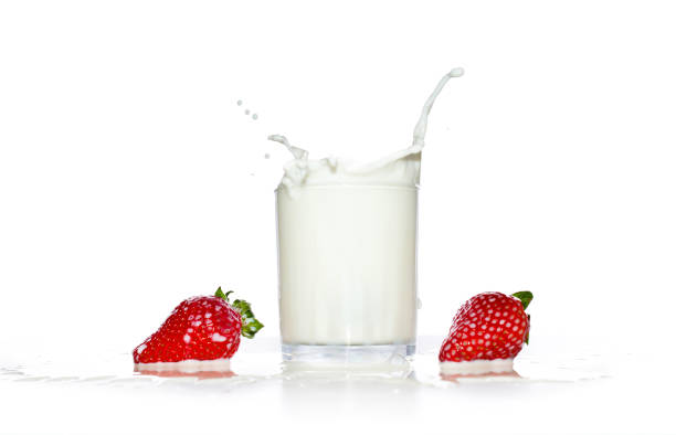 Strawberry falls into a glass of milk