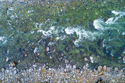 Aerial shot of a mountain river flowing among the stones