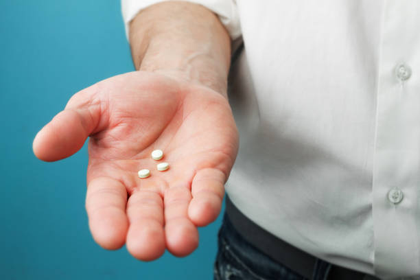 Pills in hands of men Three white tablets in hands of men contraceptive photos stock pictures, royalty-free photos & images