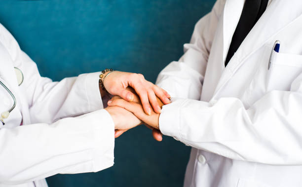 istock Two doctors putting their hands together 948217060