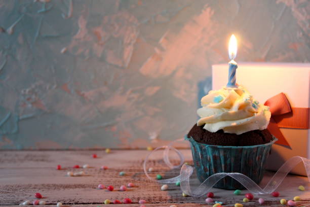 istock Cupcake with birthday candle and gift box. Top view. 948239818