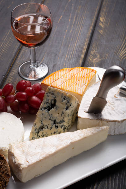 istock French cheeses plate in assortment, blue cheese, brie, munster, soft goat cheese, Neufchatel served with rose wine 948240330