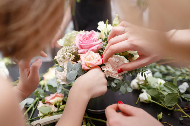 istock Master class on making bouquets for kids. Spring bouquet in metal ornamental flowerpot. Learning flower arranging, making beautiful bouquets with your own hands 948245532