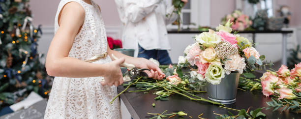istock Master class on making bouquets for kids. Spring bouquet in metal ornamental flowerpot. Learning flower arranging, making beautiful bouquets with your own hands 948245566