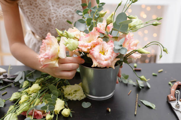 istock Master class on making bouquets for kids. Spring bouquet in metal ornamental flowerpot. Learning flower arranging, making beautiful bouquets with your own hands 948246072