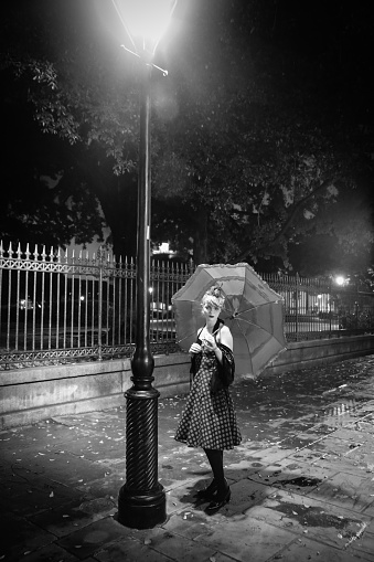 Blonde Vintage Style Gothic Woman Holding Umbrella Under Street Light