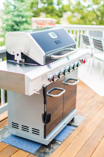 istock Six burner outdoor gas grill with open lid on back patio. 948250772