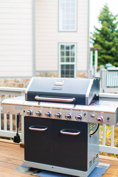 istock Six burner outdoor gas grill with open lid on back patio. 948250852