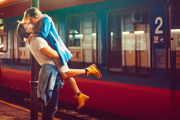 jeune passionnée et femme embrasse à côté du train à la gare - activité romantique photos et images de collection