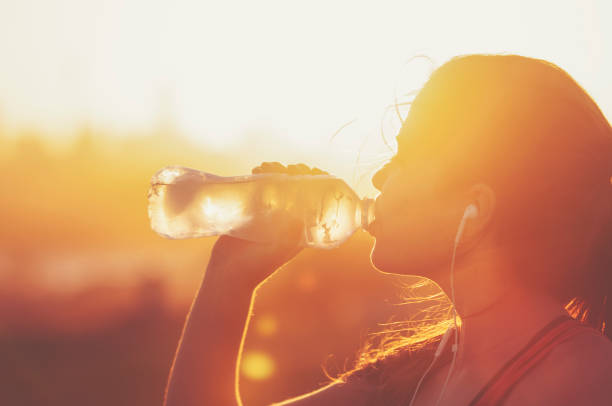 istock Silhouette of a woman drinking form a water bottle 948266524